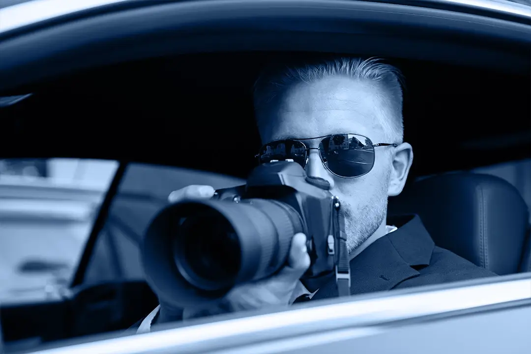 Ein Detektiv in einem Auto mit Kamera